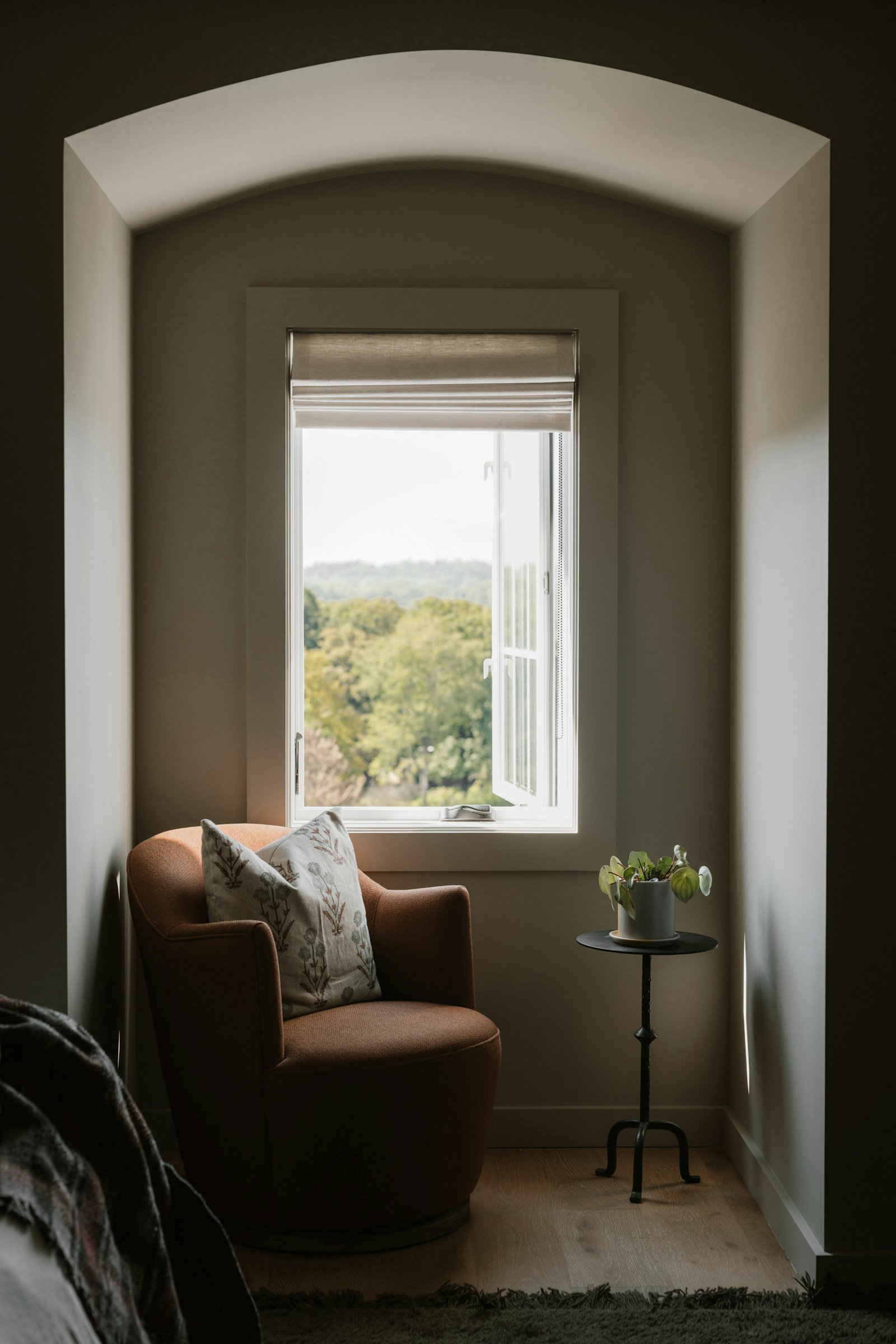 An armchair by a window with a large-type message on a nearby screen
