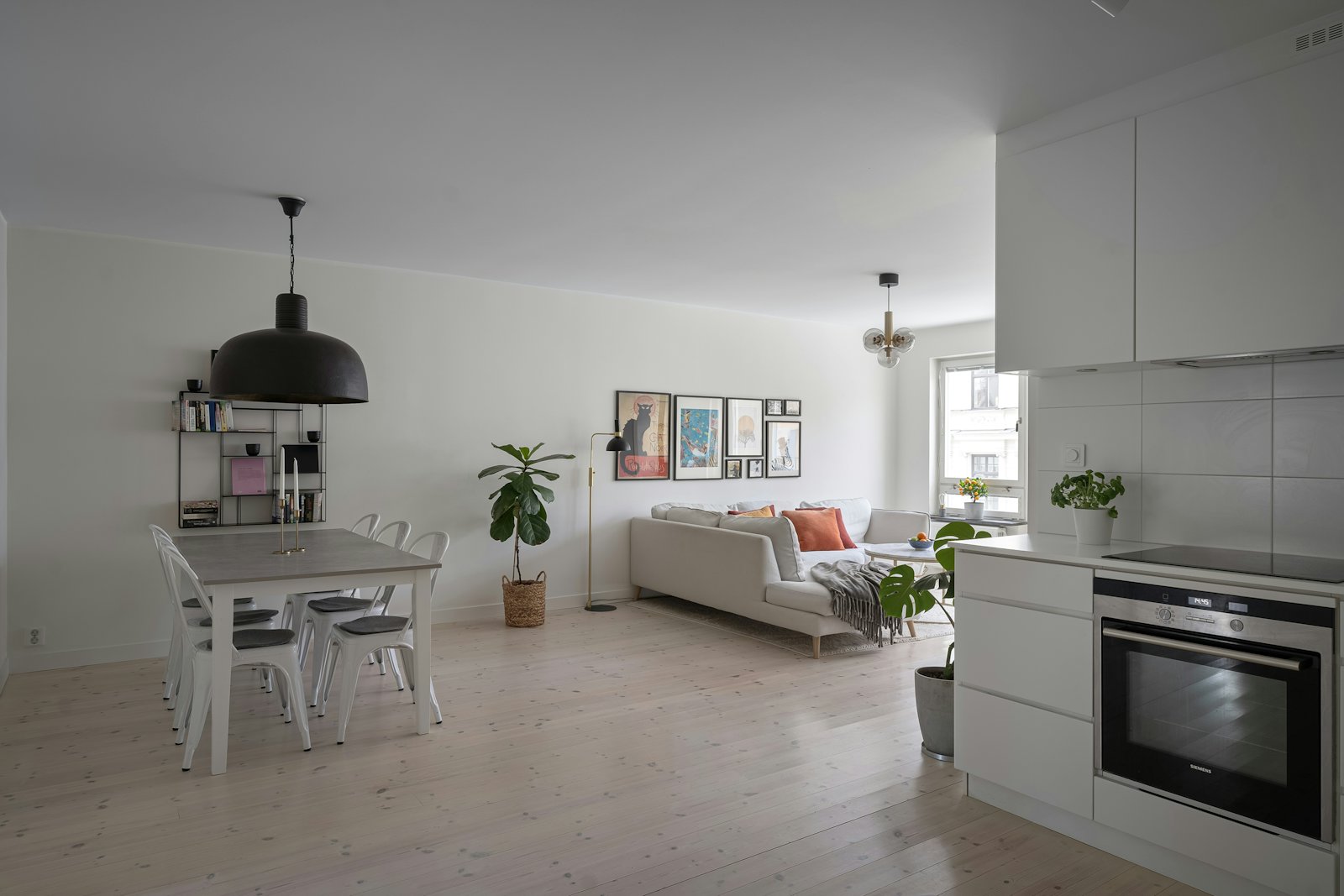 An open-plan kitchen with a screen showing the weather